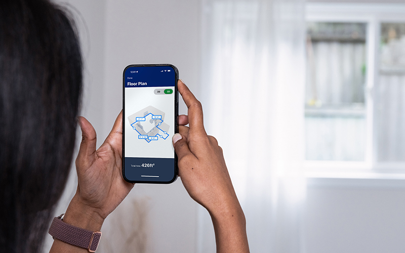Woman using mobile phone and Lowe's App to measure room